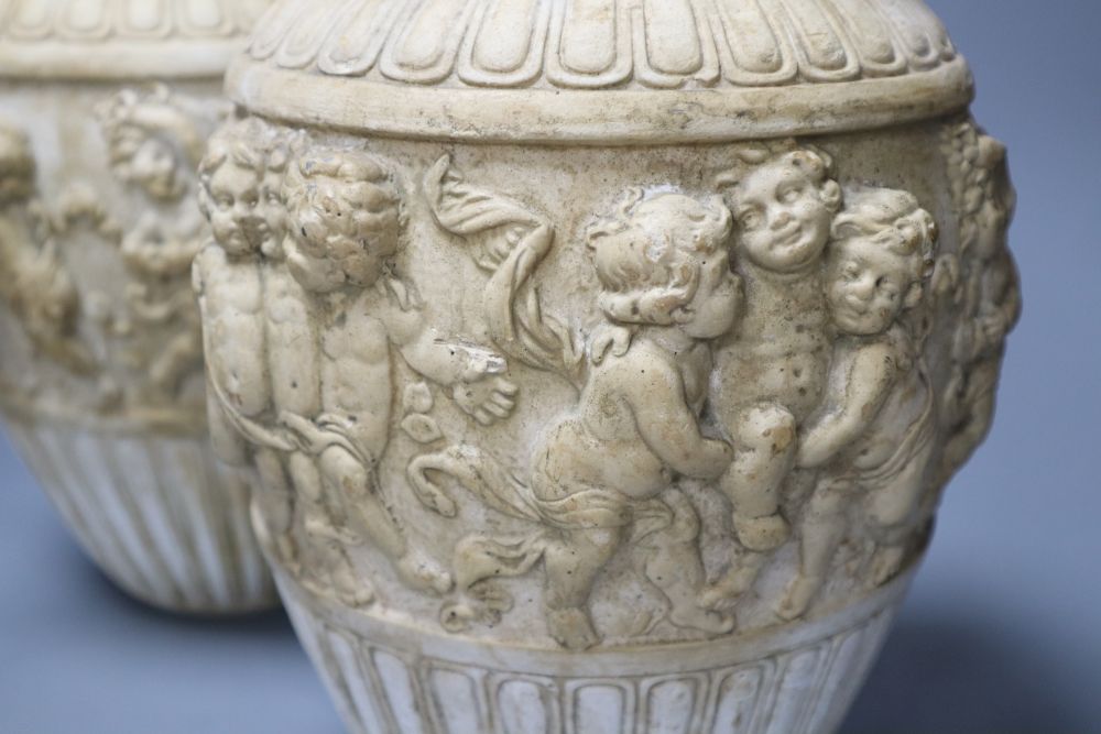 A pair of 19th century earthenware vases relief moulded in Italian Renaissance style, 30cm